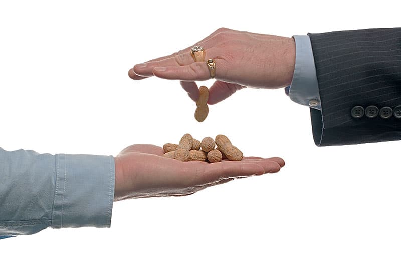 Boss handing employee peanuts for pay